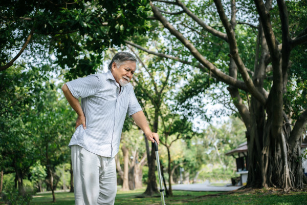 old-man-with-cane-suffering-from-back-pain-BKKC2XA