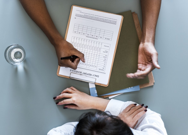 aerial-view-of-doctor-writing-patient-daily-report-PAMN3UA